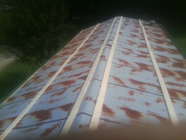 Rusted metal roof panels with new wood purlins before replacement — Storm Damage Roof Repair in Henning by Roofing Brothers